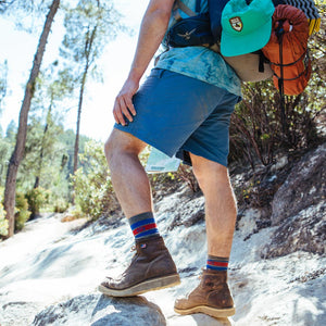 Backpacker wearing Cloudline hiking socks on rocky trail.