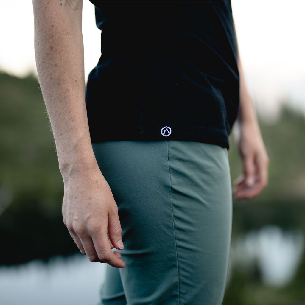 Close up of women wearing Cloudline merino base layer focusing on the logo accent at the hem. 