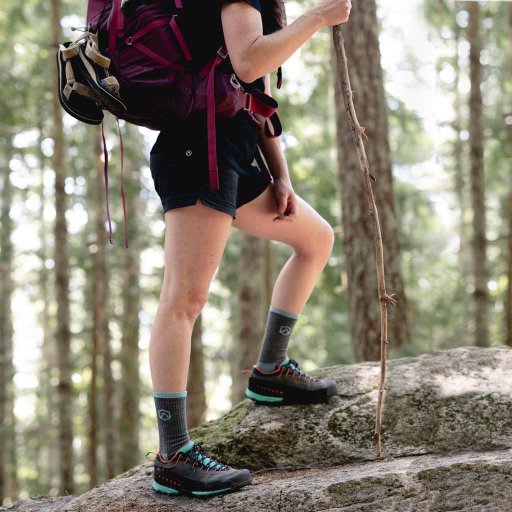 Women wearing Cloudline hiking socks, backpacking through forest trail. 